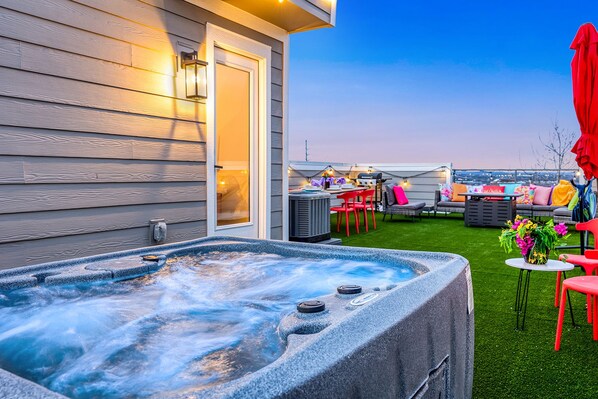 A hot tub with a view of a backyard patio area.