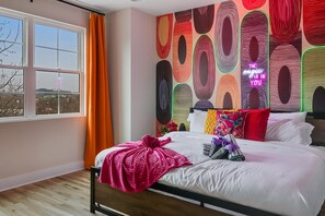 A bedroom with a bed, pillows, and a neon sign. - The Vivid - Rooftop Hot Tub/Game Room/Sleeps 16 (Nashville)