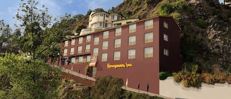 A hotel with multiple floors, a prominent entrance, and a hillside location.