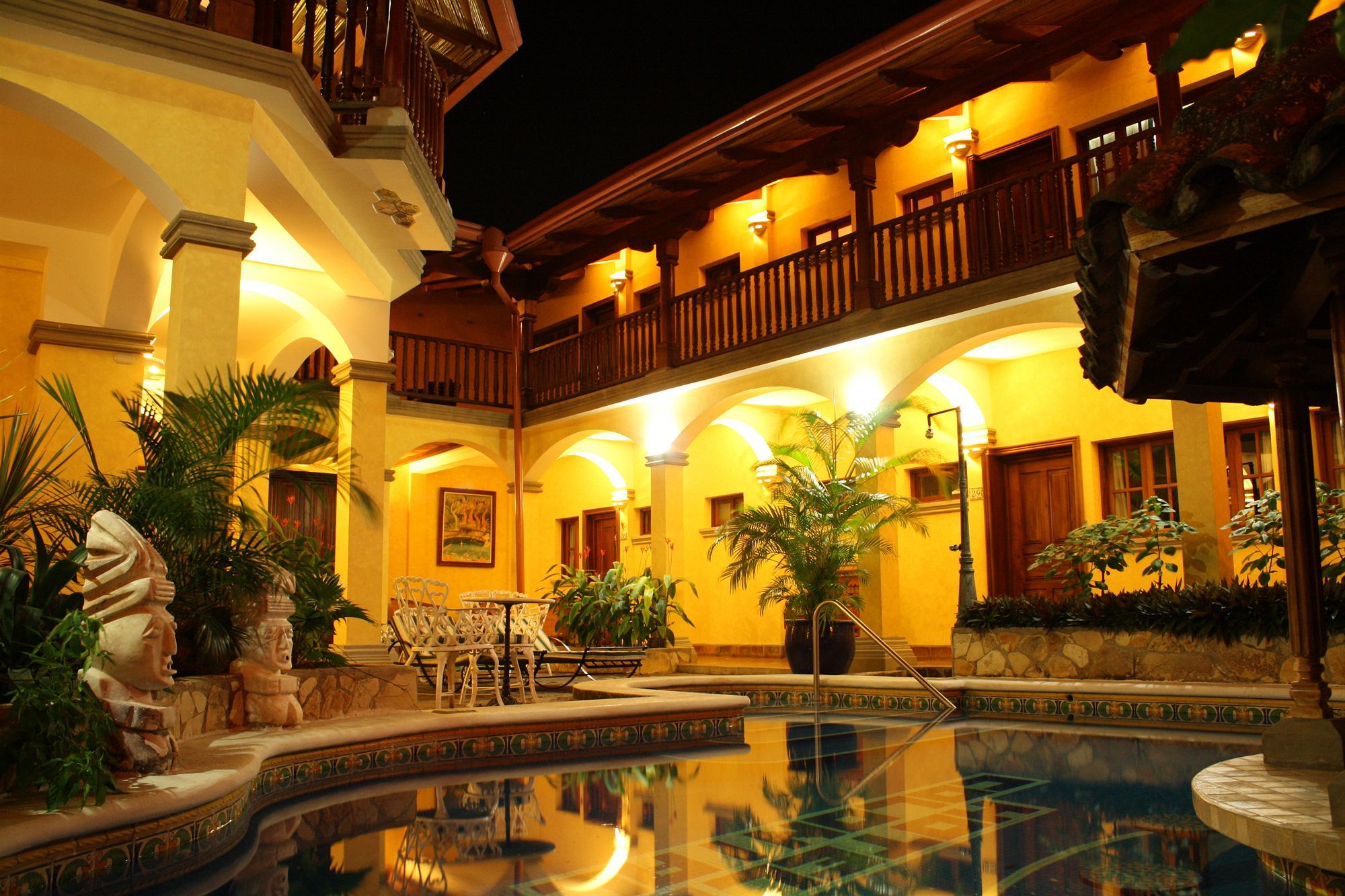 A pool area with a fountain, surrounded by outdoor seating and plants.