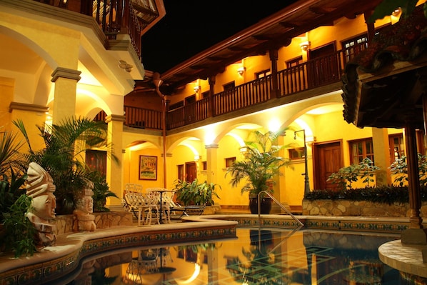 A pool area with a fountain, surrounded by outdoor seating and plants. - Colonial Granada Hotel (Granada)
