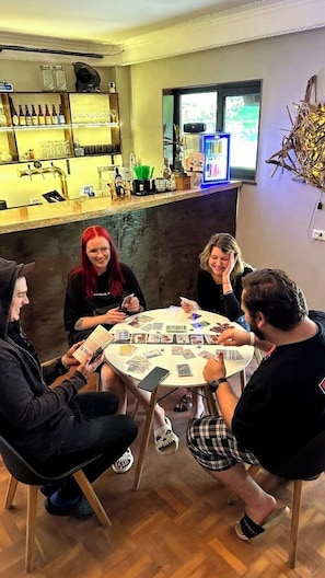 A group of people seated around a round table in a room with a bar area in the background.
