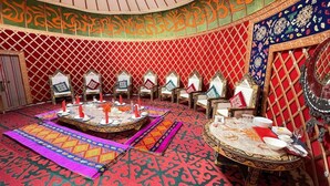 A room with a central round table, multiple chairs, and a patterned carpet. - Jannat Resort Koi-tash (Koy-Tash)