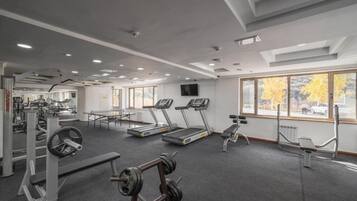A gym with treadmills, weight machines, and a bench.