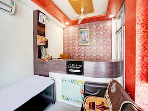 A reception area with a counter, a clock, and a framed picture on the wall. - Classic Hotel Gupta Palace (Ajmer)