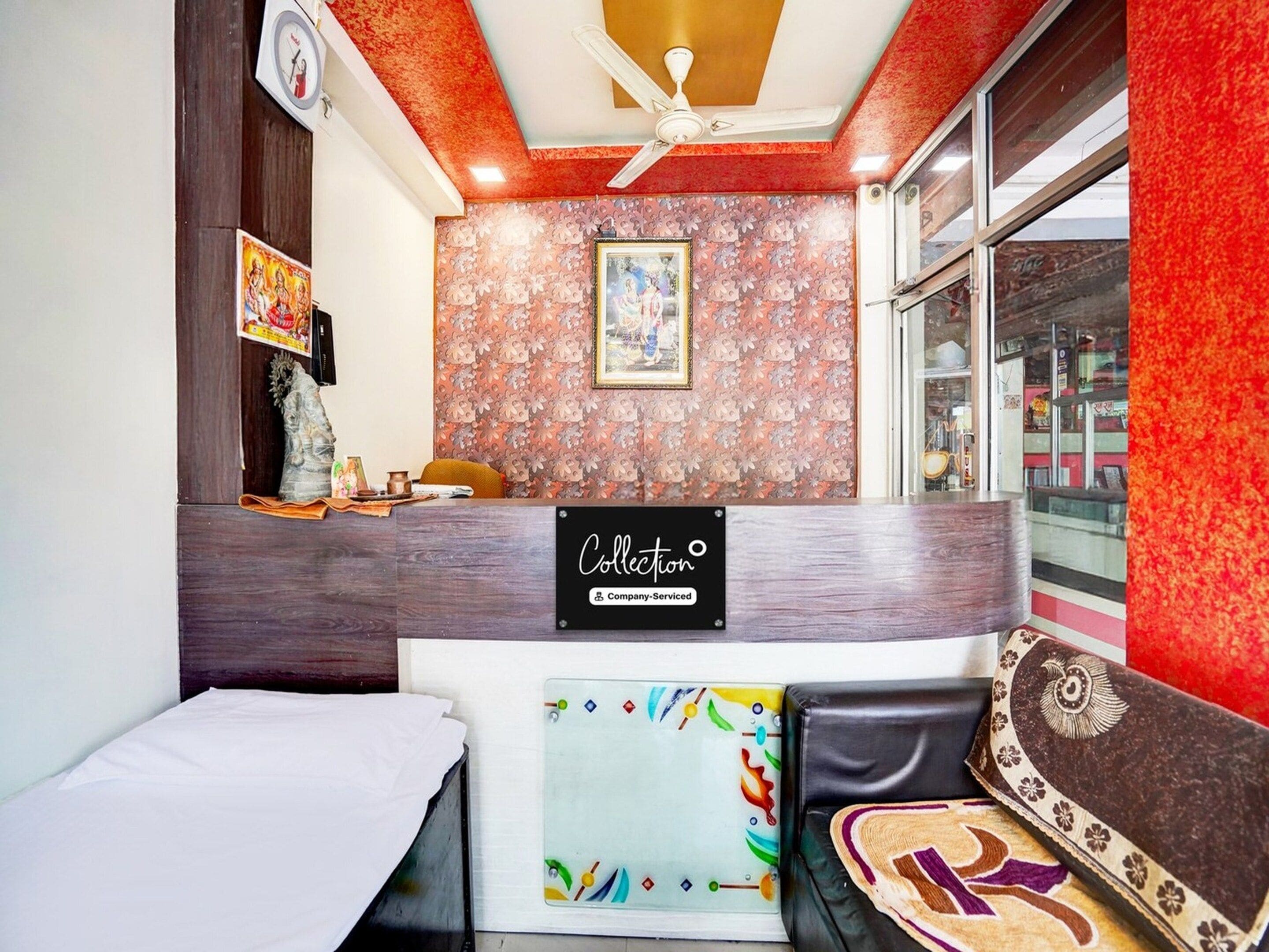 A reception area with a wooden reception desk, a framed picture on the wall, and a ceiling fan.