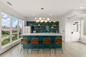 A modern kitchen with a bar area, large windows, and a city view. - 1Bd Condo in Downtown Minneapolis | Minutes from Convention Center and Stadium (Minneapolis)