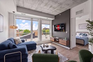 A modern living room with a sofa, coffee table, and a TV mounted on the wall. - 1Bd Condo in Downtown Minneapolis | Minutes from Convention Center and Stadium (Minneapolis)
