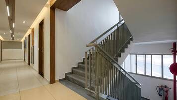 A modern interior with a staircase, a hallway, and a fire extinguisher.