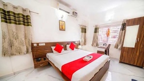 Una habitación de hotel con cama, escritorio y armario.