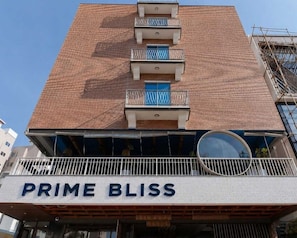 A building with a sign reading 'PRIME BLISS' and balconies with metal railings. - Deluxe With Balcony Hotel Prime Bliss (Bengaluru)
