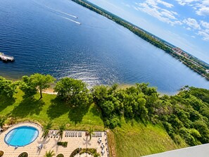 Un resort con piscina, sillas de descanso y vista al agua.