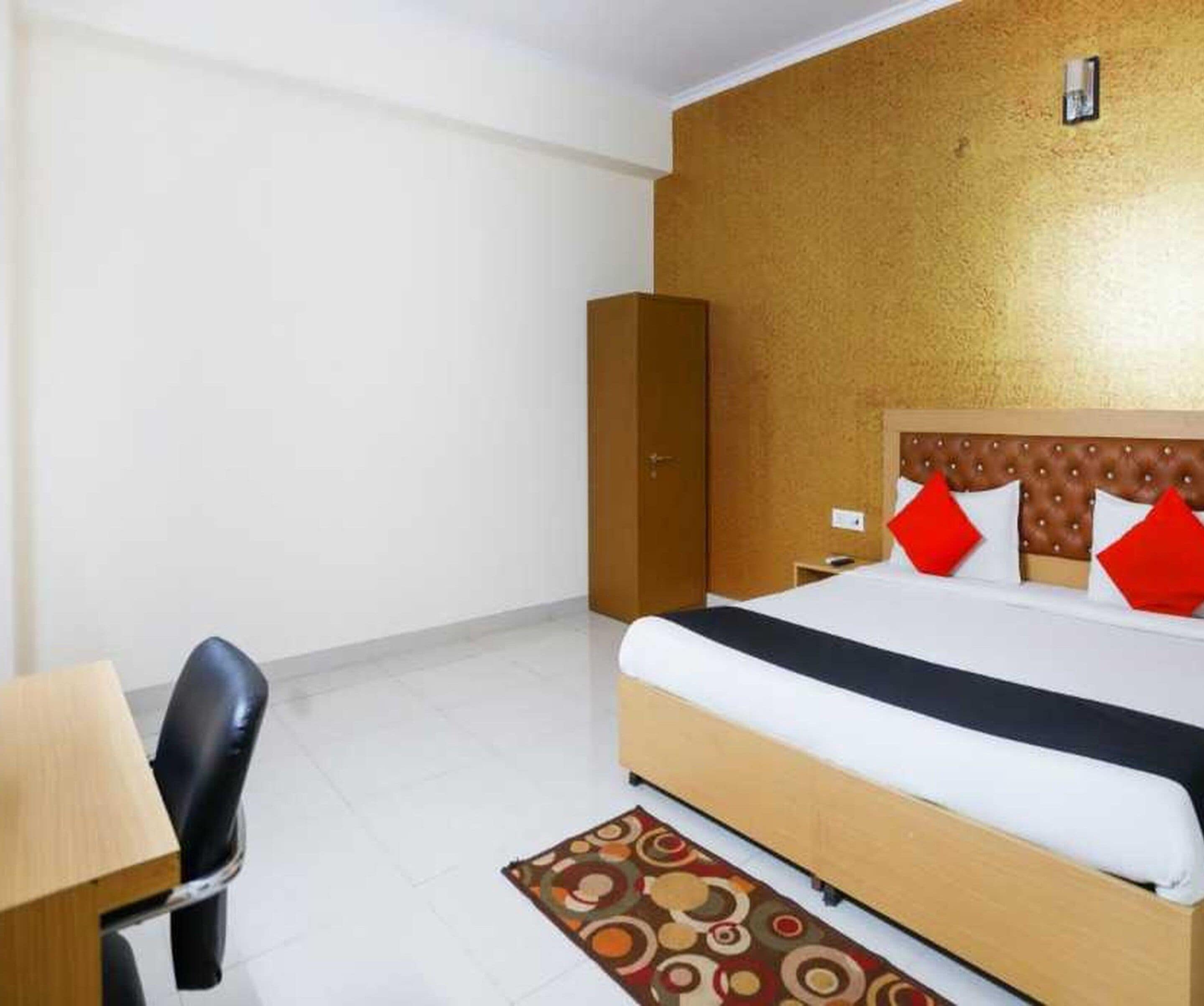 A hotel room with a bed, a desk, and a wardrobe.