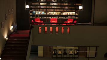 Una biblioteca con estanterías, sillas rojas y una escalera.