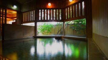 Una habitación con un ventanal grande, piso de madera y una piscina pequeña.