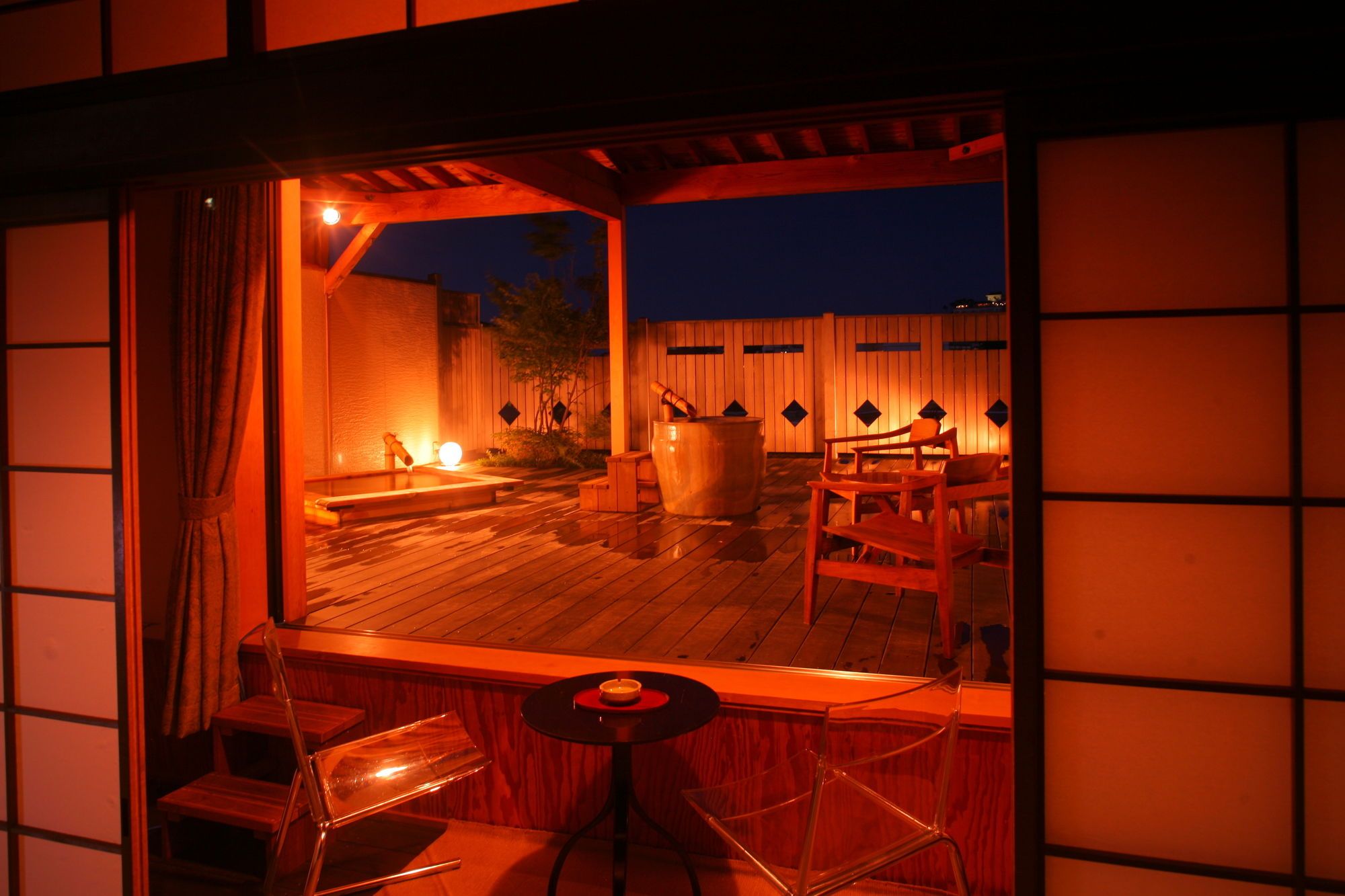 A traditional Japanese-style room with tatami flooring, a low wooden table, and a seating area with cushions.