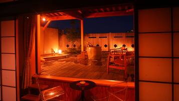 A traditional Japanese-style room with tatami flooring, a low wooden table, and a seating area with cushions.