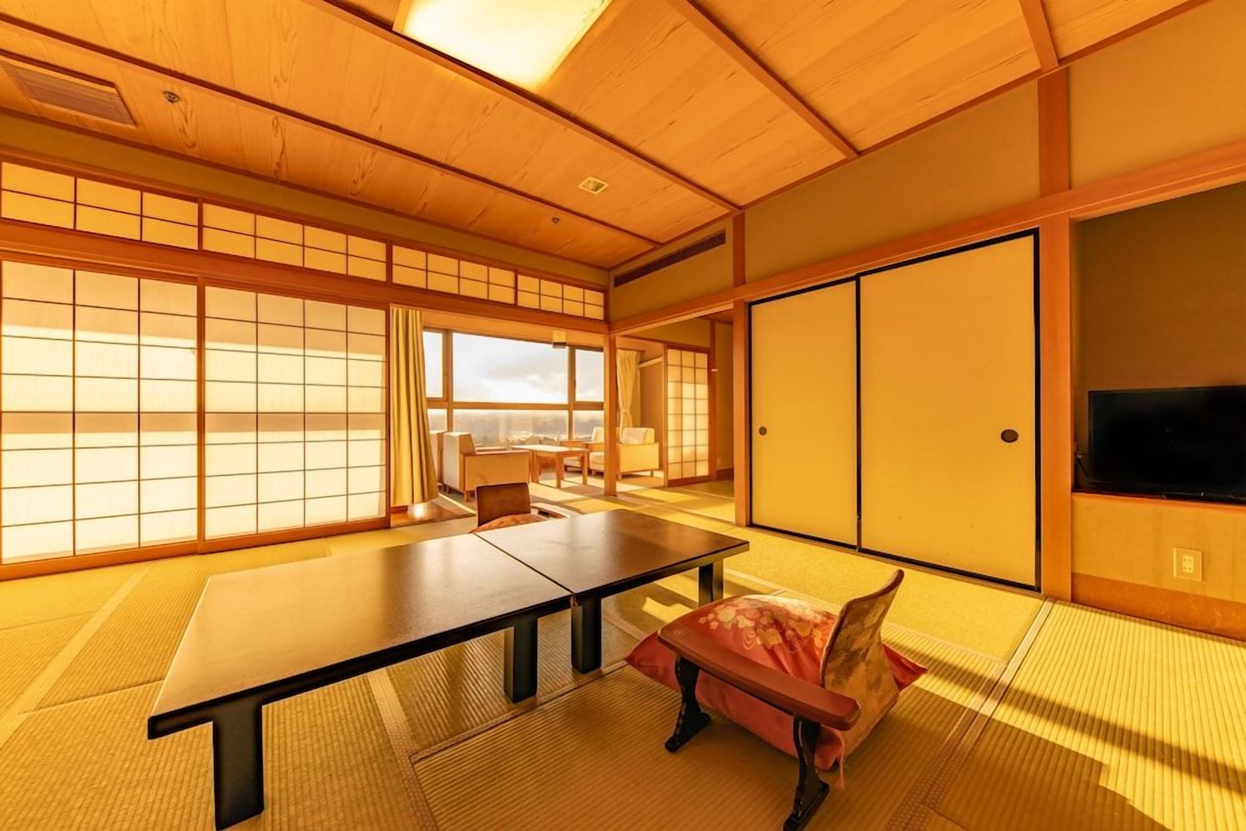 A traditional Japanese room with tatami flooring, a low table, and sliding doors.