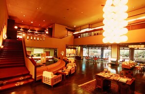 A spacious lobby with a central seating area, a staircase, and a large chandelier. - Yamashiro Onsen Onsen Meisoclub Fujiya (Kaga)
