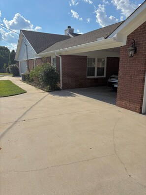 Ein Wohnhaus mit Garage, überdachter Veranda und Auffahrt.