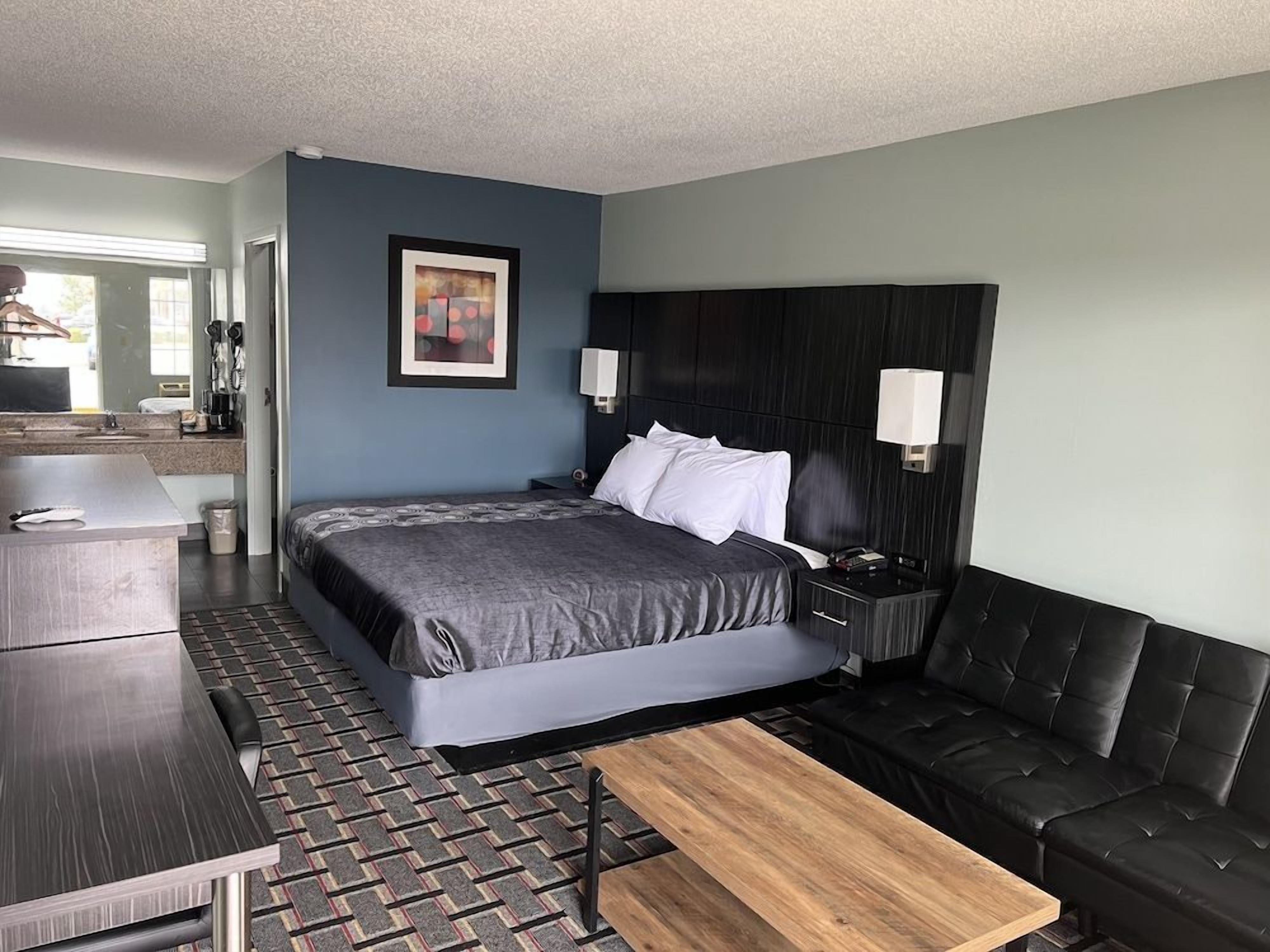 Une chambre d’hôtel moderne équipée d’un lit, d’un canapé, d’un bureau et d’une table basse.
