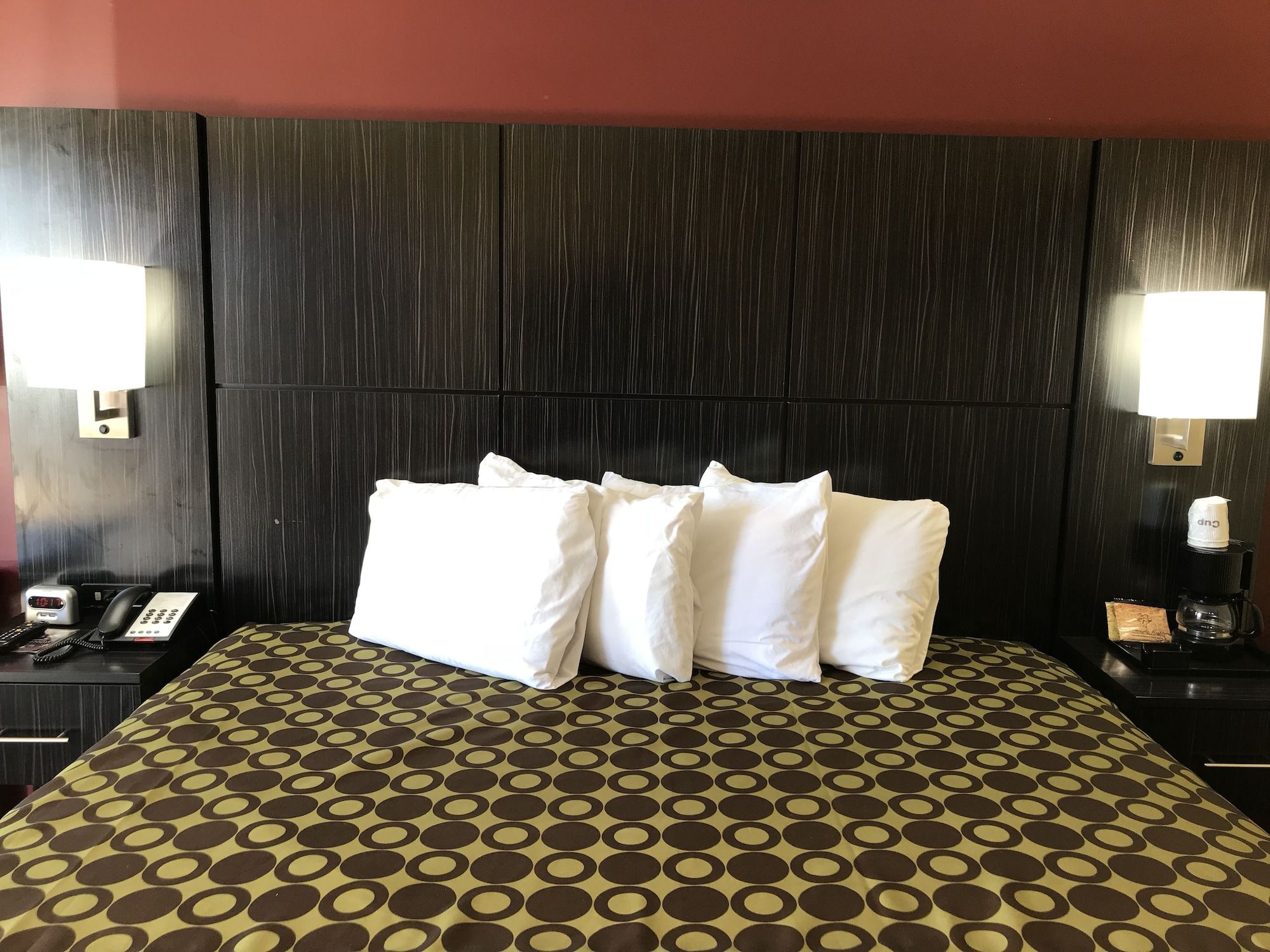 Une chambre d’hôtel avec un grand lit, deux tables de chevet, un téléphone et une lampe de chaque côté.