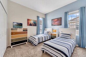 Ein Schlafzimmer mit zwei Betten, einem Schminktisch und Bildern an den Wänden.