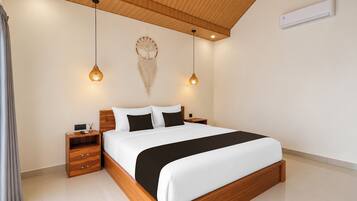 Un dormitorio moderno con estructura de cama de madera, ropa de cama blanca y dos lámparas colgantes.