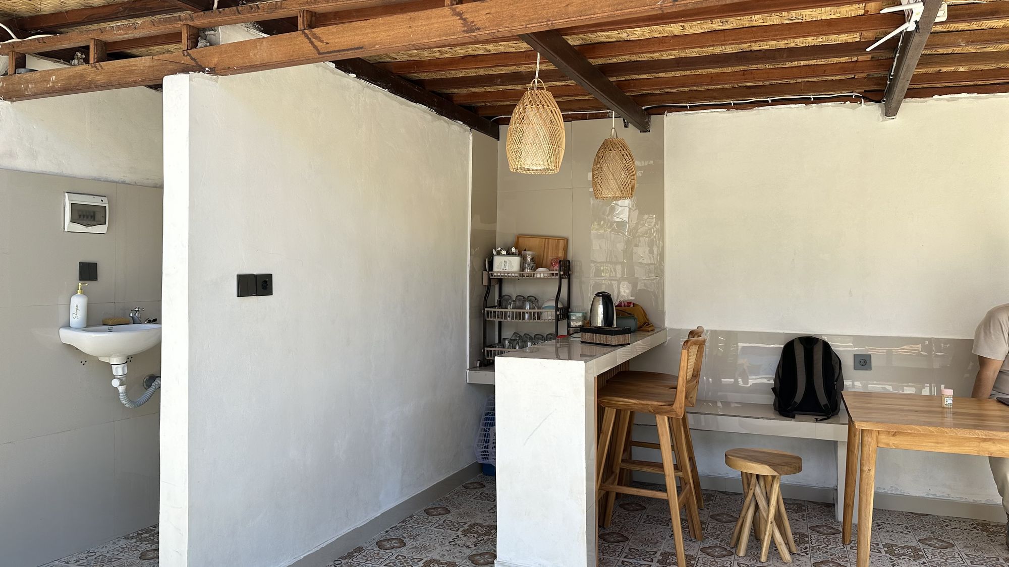 A compact kitchen with a sink, wooden stools, and a bar area.