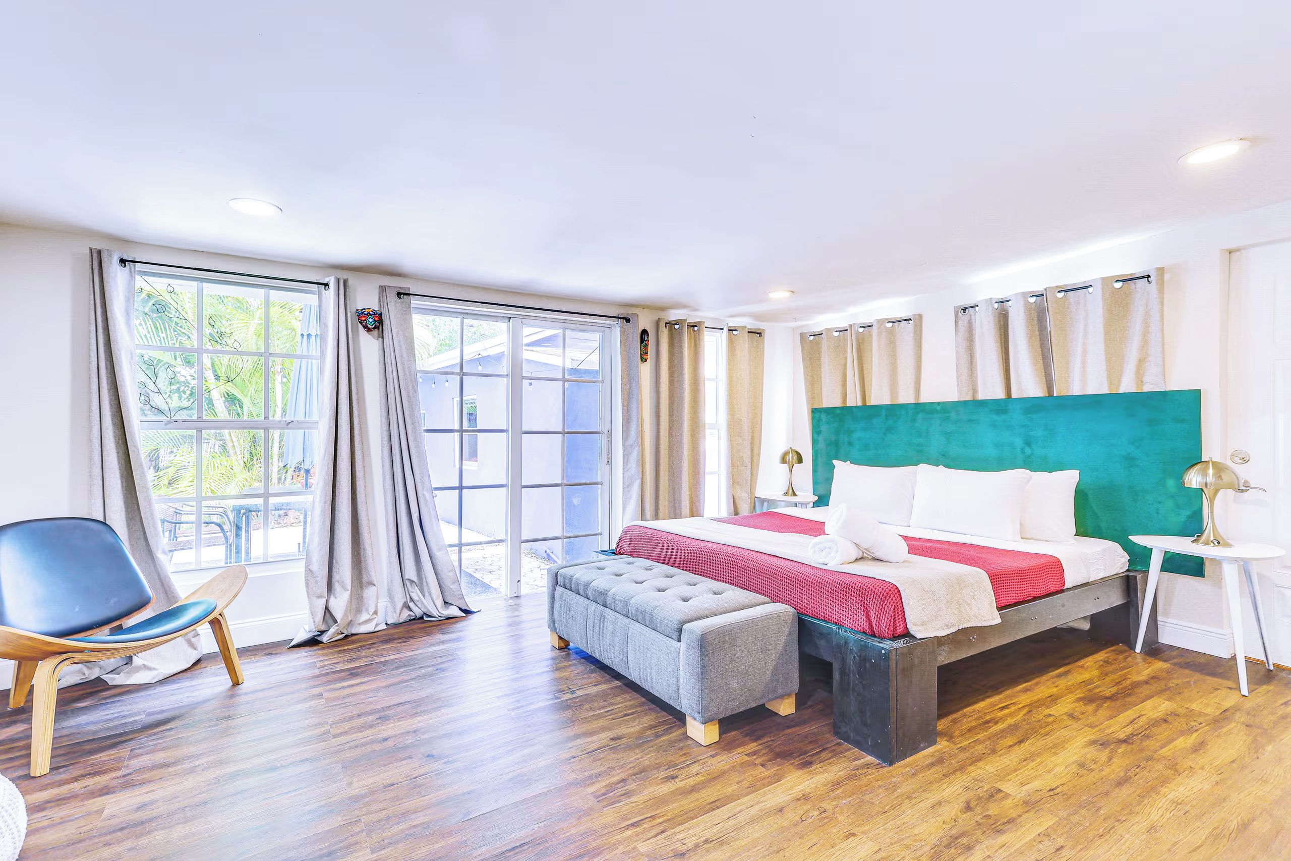 Habitación de hotel con cama, una silla, una mesa y vistas al exterior.
