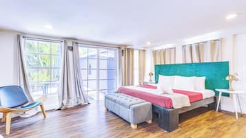 Habitación de hotel con cama, una silla, una mesa y vistas al exterior.