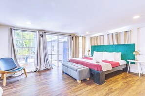 Habitación de hotel con cama, una silla, una mesa y vistas al exterior.