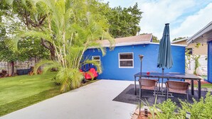 A blue house with a patio, a lawn, and a garden. - Miami Garden Retreat, Sleeps 8, Near Beaches (North Miami Beach)