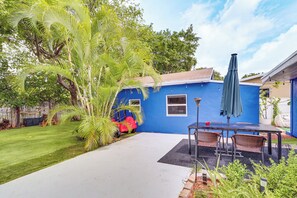 Una casa azul con un patio, césped y jardín.
