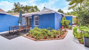 A blue house with a patio, outdoor seating, and a garden. - Miami Garden Retreat, Sleeps 8, Near Beaches (North Miami Beach)