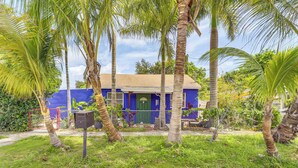 A house with a blue exterior, surrounded by palm trees and greenery. - Miami Garden Retreat, Sleeps 8, Near Beaches (North Miami Beach)
