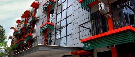 A modern building with multiple balconies, large windows, and a flat roof.