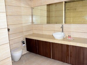 A bathroom with a white sink, dark wooden cabinets, and a mirror above the sink. - OYO Rooms Sampatrao Colony Alkapuri (Vadodara)