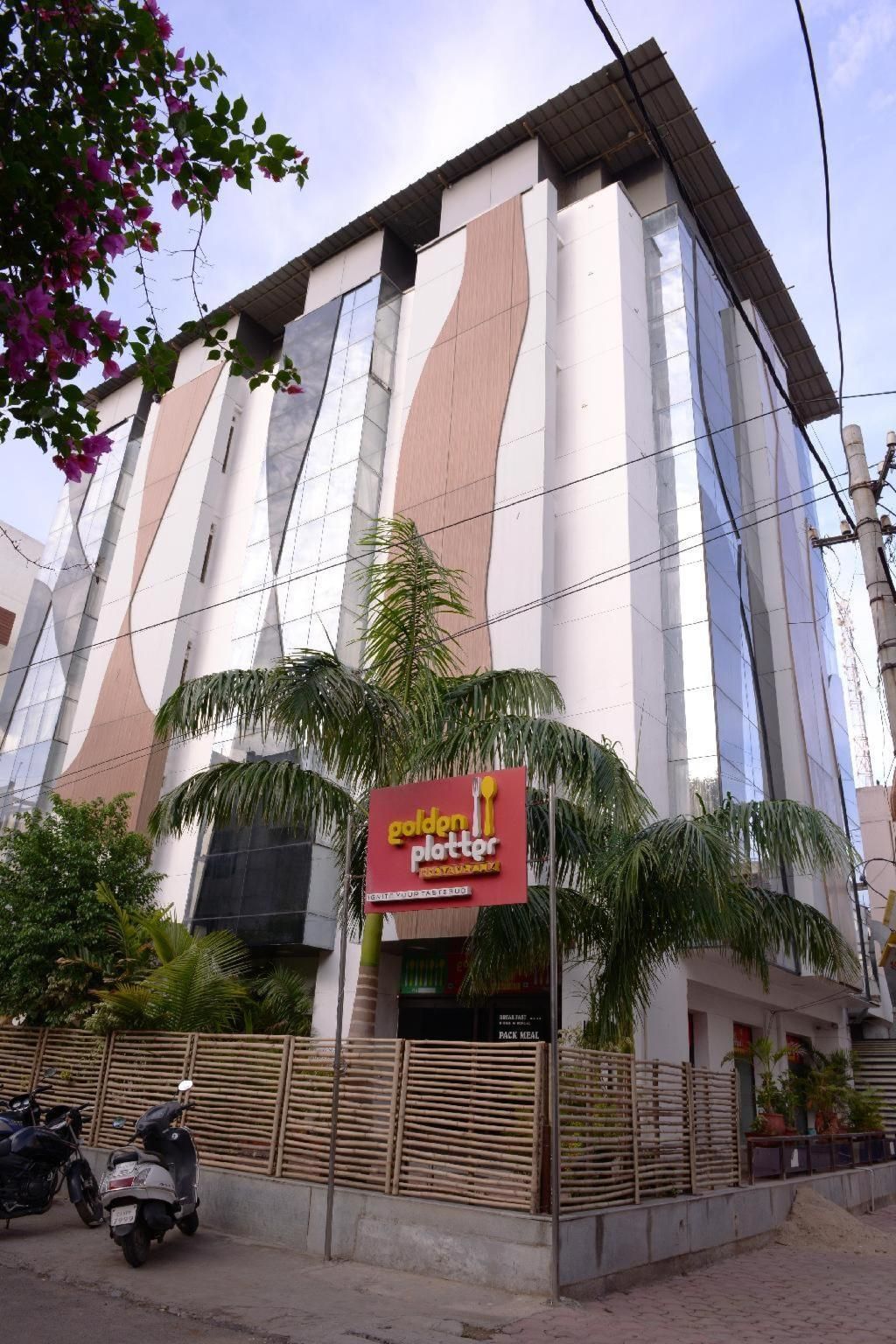 A building with a modern architectural design, featuring a prominent sign for a restaurant named 'Golden Platter.'