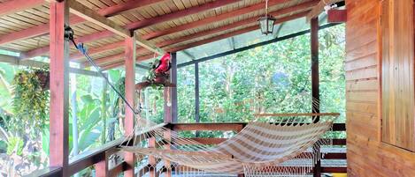 A wooden deck with a hammock and a hanging lantern.