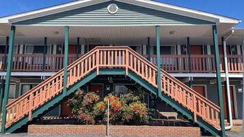 A two-story motel with a central staircase and a covered front porch.