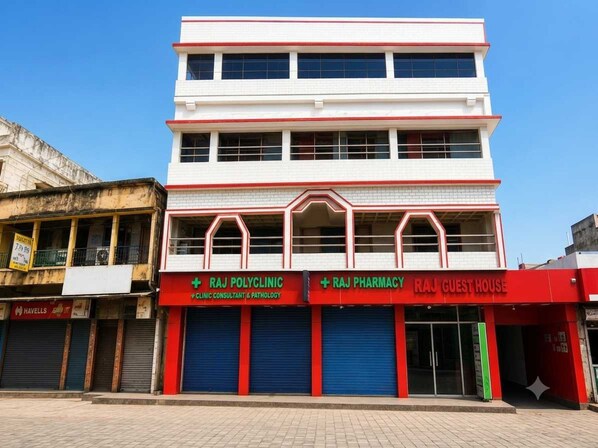 A multi-story building with signage for Raj Polyclinic, Raj Pharmacy, and Raj Guest House. - Deluxe Raj Guest House (Barakpur)