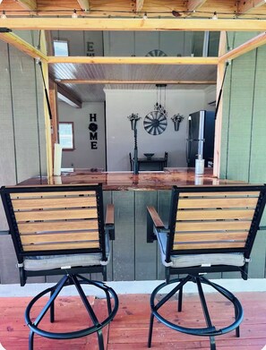 Un coin repas avec une table en bois et deux chaises, une horloge et un réfrigérateur.