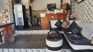 A living room with a sofa, a coffee table, and a reception desk.