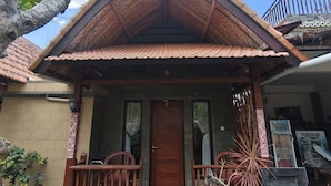 A two-story building with a tiled roof and a wooden porch.