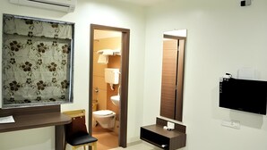 A modern bathroom with a toilet, sink, and mirror. - OYO Rooms Kanak Road (Rajkot)