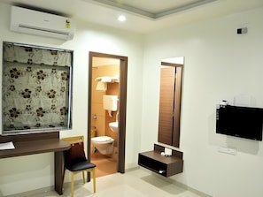 A modern bathroom with a toilet, sink, and mirror. - OYO Rooms Kanak Road (Rajkot)