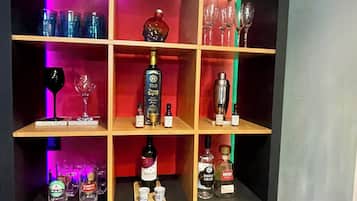 A bar area with shelves containing bottles and glasses.