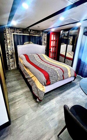 Une chambre à coucher moderne avec un lit, une chaise et un miroir.