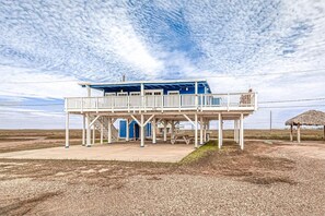 A two-story building with a balcony, a covered area, and a number '326' sign. - Entire beach home in Surfside Beach TX with boat parking, fishing, crabbing... (Surfside Beach)